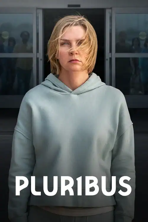 A cinematic close-up of Rhea Seehorn as Carol Sturka standing in front of glass doors. She is wearing a grey hoodie with a determined expression while silhouettes of people are visible in the background. The title "PLUR1BUS" is displayed in white text at the bottom.