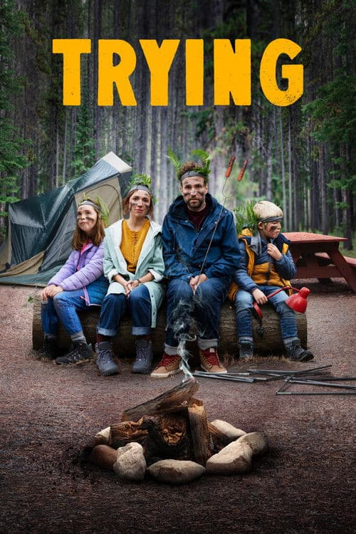 Poster for the Apple TV+ comedy Trying showing a couple and two children sitting at a campsite around a campfire in the woods.