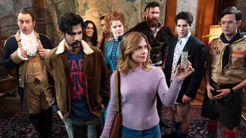 The living couple stand at the center holding an object as the ghosts gather around them, watching closely with mixed reactions.