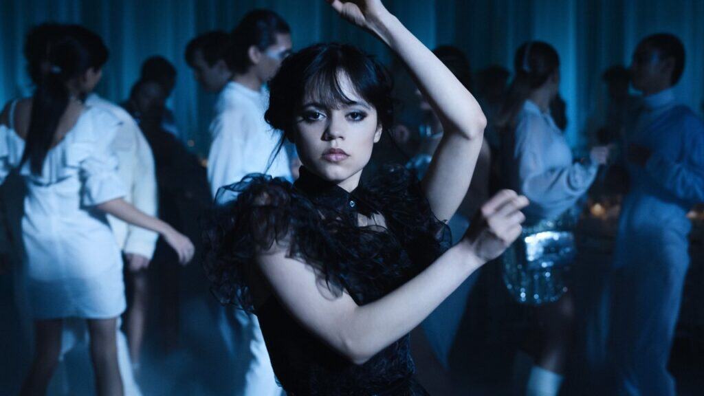 Wednesday Addams dancing alone at a school event in a dark, stylized setting