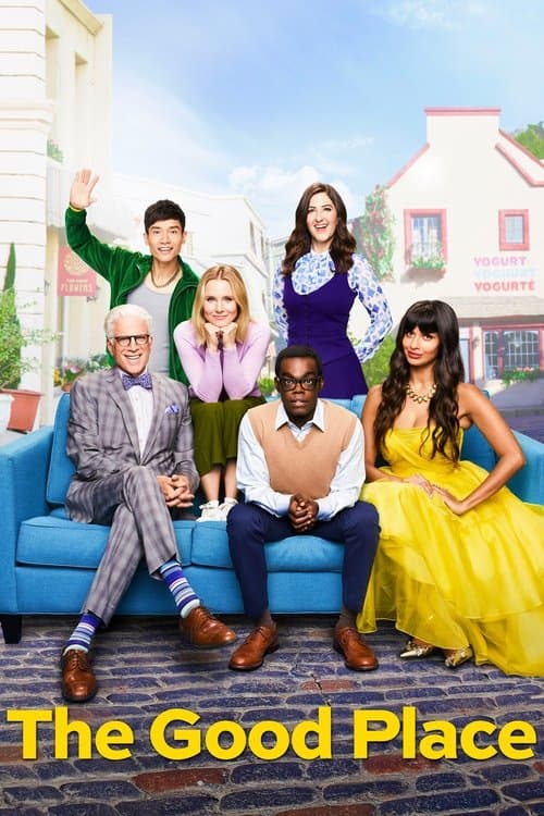 The main cast of The Good Place, including Ted Danson and Kristen Bell, sitting on and around a blue sofa in a brightly colored, whimsical town square.