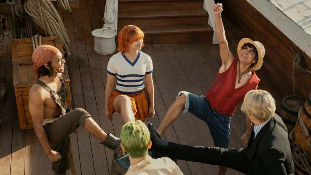 The Straw Hat pirate crew laughing and celebrating together on the wooden deck of their ship