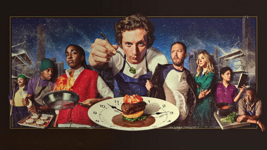 The Bear TV series cast surrounding chef Carmy during an intense moment in a busy Chicago restaurant kitchen