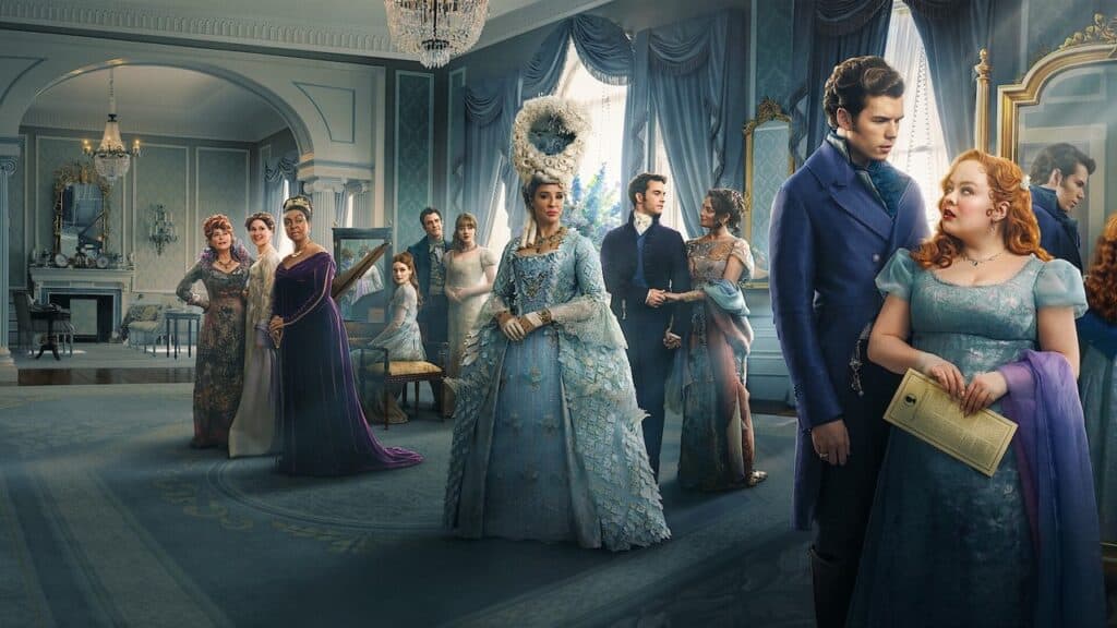 A large group of aristocratic characters in ornate Regency clothing stand inside an elegant blue ballroom, arranged in small conversational clusters.