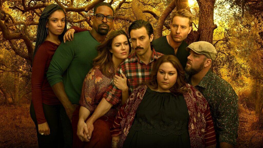 The main cast of This Is Us stands closely together in a dramatic group shot from the series.