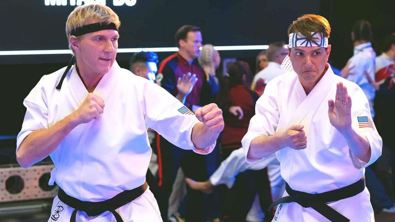 Johnny Lawrence and Daniel LaRusso facing each other in karate stances during a tournament scene in Cobra Kai
