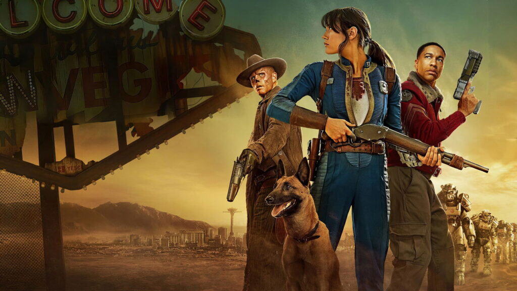 Wide Fallout promotional image showing Lucy holding a rifle with The Ghoul, Maximus, and Dogmeat in front of a damaged New Vegas sign and desert skyline.