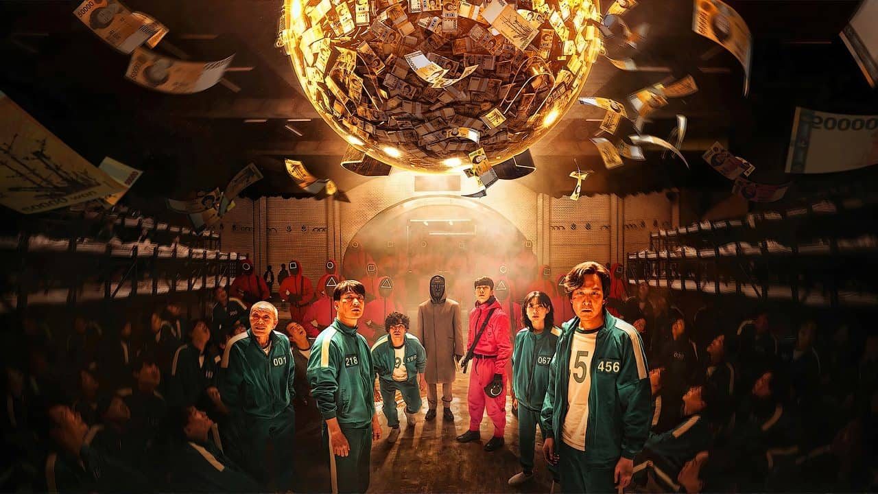 Contestants look up at a giant glowing sphere filled with money suspended above them, representing the life-changing reward that drives the brutal competition.